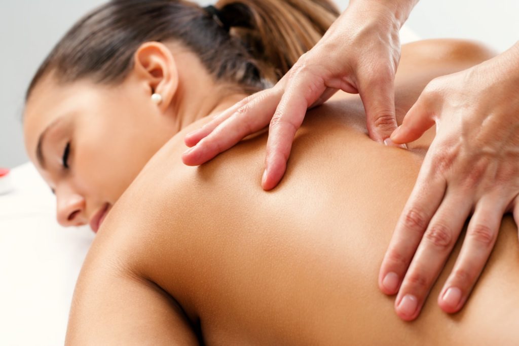 lady is having sensual body massage by a male therapist.